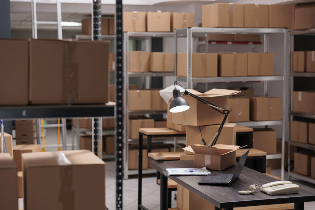 Empty storehouse delivery department with nobody in it full with rows of shelves with carton boxes